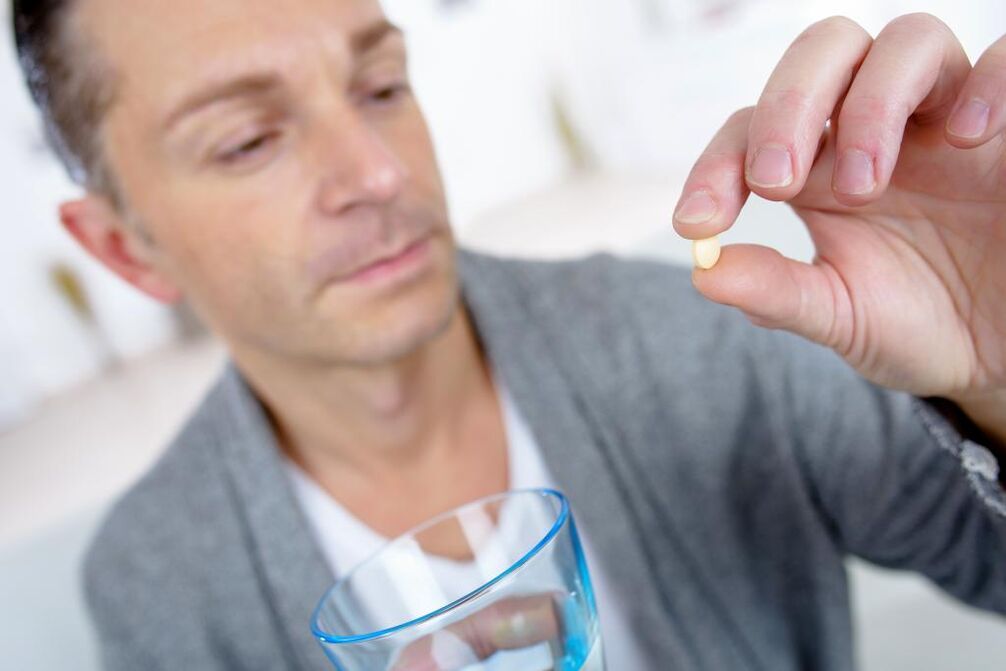 muškarac pije tabletu za povećanje potencije